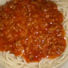 Porcja spaghetti z bogatym sosem bolońskim. Idealny prosty przepis na spaghetti z mięsem mielonym dla całej rodziny.