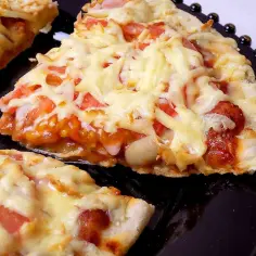 Szybka pizza z ciągnącym serem, pomidorami i kawałkami kiełbaski. Idealna na szybki głód.