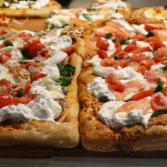 Pyszny spod do pizzy z burratą, pomidorkami i łososiem. Obok wersja z tuńczykiem i pomidorkami.