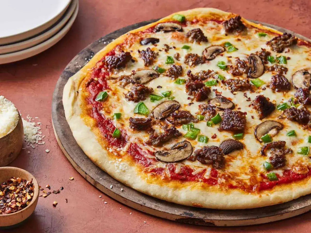 Szybka pizza z mielonym mięsem, pieczarkami i papryką, posypana płatkami chili. Idealna na szybki obiad.